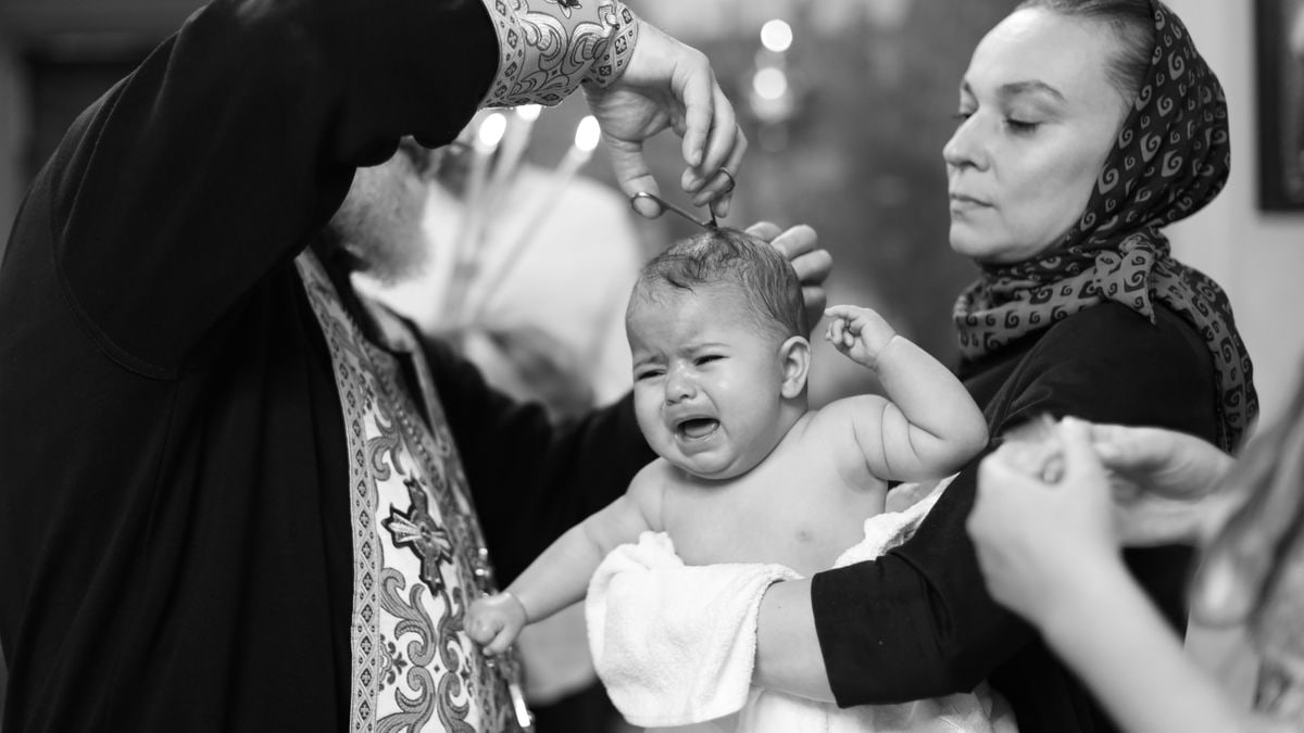 Emotional moment captured during a traditional baptism in a church setting.
